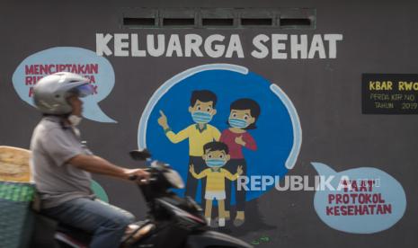 Pengendara melintas didepan mural bertema keluarga sehat di Ngemplak, Solo, Jawa Tengah, Rabu (14/7/2021). Berdasarkan hasil uji whole genome sequencing (WGS) dari 16 sampel yang dikirimkan Kota Solo ke Laboratorium di Jawa Tengah semuanya menunjukan strain berkode B.1.617.2 atau Varian Delta, hal ini diperkirakan menjadi penyebab melonjaknya angka kasus COVID-19 di Kota Solo. 