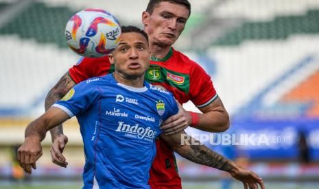 Pesepak bola Persib Bandung Mailson Lima (kiri) berebut bola dengan pesepak bola Persebaya Surabaya Slavko Damjanovic (kanan) pada pertandingan BRI Liga 1 di Stadion Si Jalak Harupat, Kabupaten Bandung, Jawa Barat, Jumat (18/10/2024). Pertandingan tersebut Persib Bandung menang dengak skor 2-0.  