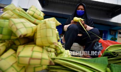 Seorang pedagang mengenakan masker saat menjual sarang ketupat untuk persiapan Hari Raya di Pasar Batu Merah, Kota Ambon, Maluku. Ilustrasi. Stok Bahan Pokok di Maluku Jelang Idul Fitri Dipastikan Aman