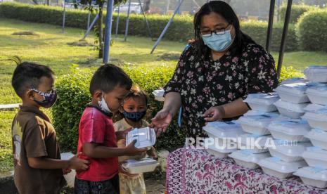 Mahasiswa memberikan makanan gratis kepada anak-anak di Universitas Kristen Indonesia (UKI), Cawang, Jakarta, Selasa (16/3). Kegiatan berbagi makanan gratis yang dilakukan oleh civitas akademi UKI itu diselenggarakan selama tiga bulan dengan memberikan 500 bungkus nasi, masker dan vitamin setiap harinya sejak pukul 06.00 WIB, untuk meringankan beban masyarakat di masa pandemi Covid 19. 