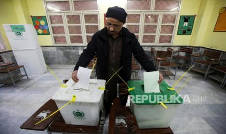 Seorang pria memberikan suaranya di tempat pemungutan suara saat pemilihan umum di Peshawar, Pakistan, (8/2/2024).  