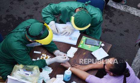 Petugas kesehatan mengambil sampel darah pedagang pasar saat tes cepat (rapid test) COVID-19 di Pasar Sleko, Kota Madiun, Jawa Timur, Minggu (3/1/2021). Pemkot Madiun memfasilitasi tes cepat bagi pedagang dan orang yang berkegiatan di empat pasar yaitu Pasar Sleko, Kawak, Kojo dan Sri Jaya sebagai upaya pencegahan penularan COVID-19 menyusul adanya puluhan orang dinyatakan positif COVID-19 berdasarkan hasil tes ucap PCR dan beberapa orang diantaranya meninggal dunia. 