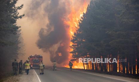  FILE - Dalam arsip foto Rabu, 16 Juni 2021 ini, petugas pemadam kebakaran bekerja di lokasi kebakaran hutan di dekat desa Andreyevsky di luar Tyumen, Siberia barat, Rusia. Kebakaran hutan di Siberia melepaskan sejumlah besar gas rumah kaca, kata para ilmuwan, yang berkontribusi terhadap pemanasan global. Setiap tahun, ribuan kebakaran hutan melanda sebagian besar wilayah Rusia, menghancurkan hutan dan menyelimuti wilayah yang luas dengan asap tajam.