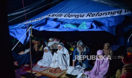 Pengungsi melaksanakan shalat di dalam tenda darurat di Kampung Gitung, Desa Mangunkerta, Kecamatan Cugenang, Kabupaten Cianjur, Jawa Barat, Ahad (27/11/2022). Beberapa pengungsi korban gempa Cianjur mengisi waktu malam hari di tenda pengungsian dengan menggelar tahlil atau menyaksikan pertandingan piala dunia. 