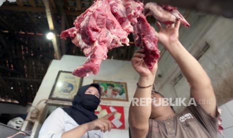 Penjual daging sapi memeriksa kualitas barang dagangan (ilustrasi).