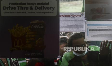 Sejumlah pengendara ojek online saat mengantre untuk mengambil pesanan BTS Meal di McDonalds Raden Saleh, Cikini, Jakarta, Rabu (9/6). Satpol PP DKI Jakarta menutup sementara McDonalds Raden Saleh  karena terjadinya kerumunan yang mengabaikan protokol kesehatan. Kerumunan tersebut diakibatkan pesanan BTS Meal yang merupakan menu kolaborasi boy band asal Korea BTS dengan McDonalds yang hadir di 50 negara, termasuk Indonesia. Republika/Putra M. Akbar