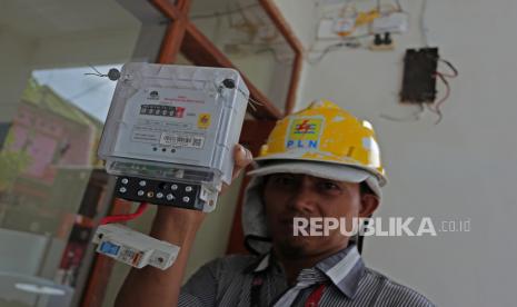 Teknisi memperlihatkan meteran listrik PLN.