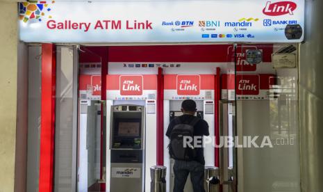 Nasabah melakukan transkasi melalui mesin anjungan tunai mandiri (ATM) di Jakarta.