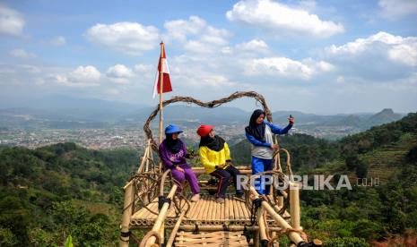 Wisatawan berswafoto dengan latar Kota Sumedang, di Puncak Gunung Pangadegan, Desa Rancamulya, Kabupaten Sumedang, Jawa Barat, Rabu (2/9/2020). Jatuh akibat selfie di ketinggian bisa bahayakan nyawa. 