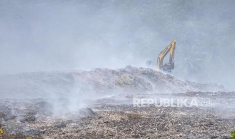 Petugas menggunakan alat berat menguruk tanah untuk memadamkan api di TPA Sarimukti, Cipatat, Kabupaten Bandung Barat, Selasa (12/9/2023). Pemerintah Provinsi Jawa Barat melanjutkan status tanggap darurat bencana kebakaran TPA Sarimukti yang tidak kunjung padam sejak 23 hari lalu. Status tersebut akan diberlakukan hingga 25 September mendatang.