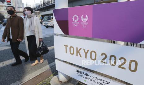  Orang-orang berjalan melewati papan nama untuk mempromosikan Olimpiade, di Tokyo, Selasa (16/2). Olimpiade dijadwalkan dibuka pada 23 Juli, tetapi jajak pendapat baru-baru ini menunjukkan sekitar 80% publik Jepang ingin Olimpiade dibatalkan atau ditunda.