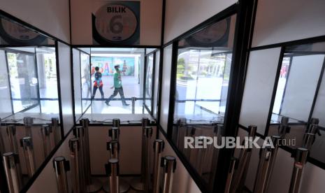 Petugas melintas di dekat bilik pemeriksaan GeNose C19 yang ditutup sementara di Terminal Domestik Bandara Internasional I Gusti Ngurah Rai, Badung, Bali, Senin (5/7/2021). 