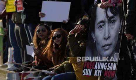 Pengunjuk rasa pro demokrasi Myanmar memegang poster yang menunjukkan wajah politisi Myanmar Aung Sang Suu Kyi, saat mereka memperingati satu tahun perebutan kekuasaan oleh militer di Parliament Square, London, Selasa, 1 Februari, 2022. Aktivis demokrasi Myanmar akan dieksekusi mati setelah permohonan bandingnya ditolak.