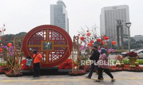 Warga melintasi ornamen bernuansa Imlek yang di pasang di kawasan Bundaran Hotel Indonesia, Jakarta, Minggu (30/1/2022). Ornamen tersebut dipasang dalam rangka menyambut perayaan Tahun Baru Imlek 2573 Kongzili yang jatuh pada hari Selasa 1 Februari 2022. 