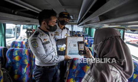 Penumpang bus memindai kode batang melalui aplikasi PeduliLindungi di Terminal Cicaheum, Kota Bandung, Senin (28/3/2022). Armada bus di Terminal Cicaheum, Bandung sudah dipenuhi pemudik pada H-7 lebaran.