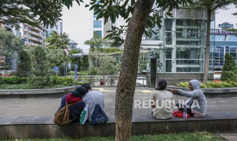  Pasangan muda duduk antara lain di trotoar di Jakarta, Ahad, 4 Desember 2022. Undang-undang pidana baru yang akan menghukum hubungan seks sebelum menikah dengan hukuman penjara diperkirakan akan disahkan oleh parlemen Indonesia bulan ini.