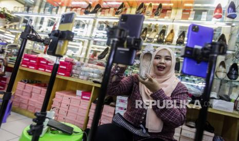 Pedagang berjualan melalui siaran langsung TikTok Shop di Pasar Tanah Abang, Jakarta. Menkop UKM Teten sebut Tiktok masih langgar aturan karena Tiktok Shop belum dipisah.