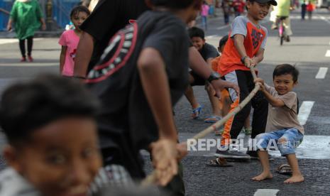 Sejumlah anak bermain tarik tambang saat Hari Bebas Kendaraan Bermotor atau Car Free Day di Jalan Tunjungan, Surabaya, Jawa Timur, Ahad (12/6/2022). Komunitas Kampoeng Dolanan menyediakan sejumlah permainan tradisional bagi pengunjung CFD guna melestarikan permainan tradisional. 