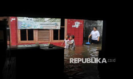 Warga beraktivitas di pemukiman yang terdampak banjir di kawasan Petukangan, Cakung, Jakarta Timur, Rabu (29/1/2025). Banjir setinggi 60-100 centimeter tersebut terjadi akibat intensitas hujan yang lebat sejak Selasa (28/1) malam yang menyebabkan Kali Buaran meluap hingga ke pemukiman. Hingga saat ini kondisi pemukiman tersebut berangsur surut namun tumpukan sampah masih menyumbat kali.