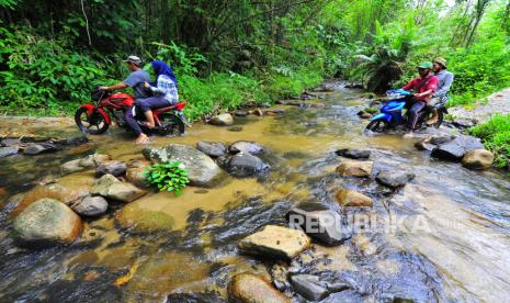 Warga menyeberangi Sungai Batang Cuban di Lubuk Bangkar, Sarolangun, Jambi, Jumat (23/10/2020). Meski hanya berjarak sekitar 80 kilometer dari pusat pemerintahan Kabupaten Sarolangun, buruknya akses jalan di sejumlah titik di daerah yang baru mendapatkan layanan listrik pada 2018 lalu itu menyebabkan jarak tempuh menuju desa dari pusat pemerintahan kabupaten bisa mencapai 4,5 jam perjalanan darat. 