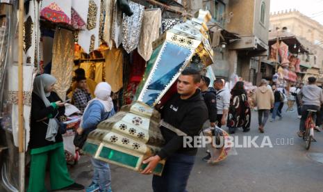 Warga membawa lentera Fanous yang dibeli di sebuah pasar di Kairo, Mesir, Senin (4/3/2024). Di Mesir, salah satu tradisi unik jelang Ramadhan adalah memasang lentera Fanous. Warga Mesir berbondong-bondong berburu lentera warna-warni itu yang memang identik dengan bulan Ramadhan.