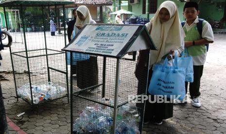 Siswa memasukkan sampah botol plastik yang telah dipilah dari rumah di MTs Al Hikam, Desa Jatirejo, Kecamatan Diwek, Kabupaten Jombang, Jawa Timur, Kamis (2/5/2024). 