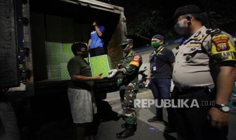 Petugas gabungan menyerahkan bantuan sembako kepada warga sebagai bantuan pangan akibat wabah COVID-19 di kawasan RW 03 Kebon Kacang, Jakarta, Ahad (12/4/2020). Bantuan sembako Pemprov DKI Jakarta tersebut guna meringankan beban perekonomian warga setempat yang terdampak COVID-19 di wilayah DKI Jakarta selama masa Pembatasan Sosial Berskala Besar (PSBB)