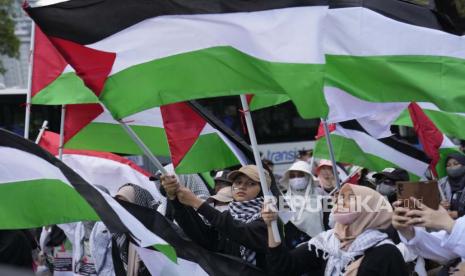  Wanita Muslim mengibarkan bendera Palestina selama demonstrasi menandai Hari Al-Quds (Yerusalem) di luar Kedutaan Besar AS di Jakarta, Jumat (14/4/2023).  Hari Al-Quds dimulai pada tahun 1979 ketika mendiang pemimpin Iran Ayatollah Khomeini mengumumkan yang terakhir. Jumat di bulan suci Ramadhan sebagai hari untuk menunjukkan pentingnya Yerusalem bagi umat Islam.