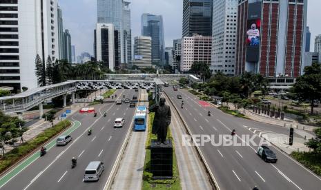 Suasana arus lalu lintas dengan salah satu gedung menampilkan videotron yang mengimbau untuk tetap di rumah pada masa Pembatasan Sosial Berskala Besar (PSBB) di kawasan Sudirman, Jakarta, Senin (13/4). Videotron yang menampilkan imbauan itu mengajak masyarakat untuk tetap di rumah untuk memutus mata rantai penyebaran virus Corona