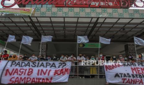 Puluhan pedagang mengibarkan bendera putih saat menggelar aksi protes kebijakan penyesuaian PPKM level 4 di Sukaramai Trade Center (STC) Pekanbaru, Riau, Selasa (10/8/2021). Mereka meminta pemerintah untuk memperhatikan nasib para pedagang yang tidak bisa menjual barang dagangannya karena tidak diperbolehkan beroperasi selama pemberlakuan PPKM Level 4 di Kota Pekanbaru.