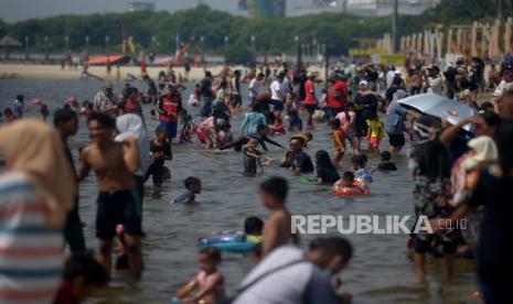 Wisatawan mengunjungi pantai di Taman Impian Jaya Ancol. Taman Impian Jaya Ancol mampu mencapai target 9 juta wisatawan.