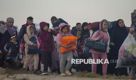 Anak Palestina berjalan kaki pulang kembali menuju rumah mereka di Jalur Gaza Utara, Senin (27/1/2025).