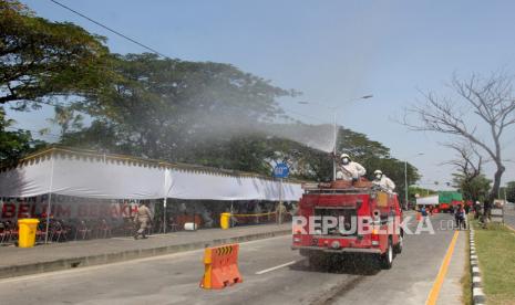 Petugas Dinas Pemadam Kebakaran Kota Surabaya menyemprotkan larutan disinfektan di area pos penyekatan Jembatan Suramadu, Surabaya, Jawa timur, Kamis (10/6/2021). Penyemprotan disinfektan dilakukan di area pos penyekatan yang menjadi tempat dilakukannya tes cepat antigen dan tes usap PCR bagi warga dari Pulau Madura yang menuju maupun melintas ke Surabaya, menyusul meningkatnya kasus COVID-19 di Bangkalan, Madura.