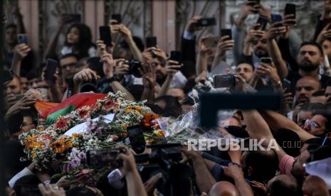 Warga Palestina mengepung jenazah jurnalis veteran Aljazirah Shireen Abu Akleh yang terbungkus bendera, di kota Ramallah, Tepi Barat, Rabu, 11 Mei 2022.