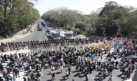  Para pengunjuk rasa meneriakkan slogan-slogan di depan petugas polisi anti huru-hara selama protes menentang kudeta militer, di Yangon, Myanmar, Selasa (9/2). Ribuan orang terus melakukan unjuk rasa di Yangon meskipun ada peringatan keras dari militer setelah beberapa hari protes massal.