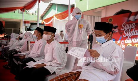 Santri menunggu giliran untuk disuntik vaksin Covid-19 Sinovac dosis pertama di Pondok Pesantren Ummul Qura, Tangerang Selatan, Banten, Ahad (1/8).  Sekitar 500 santri telah disuntik vaksin Covid-19 dosis pertama yang diselenggarakan Badan Intelejen Negara (BIN) bersama Kementerian Agama Tangerang Selatan guna mempercepat pemerataan vaksin bagi masyarakat dan kalangan pelajar. Republika/Thoudy Badai