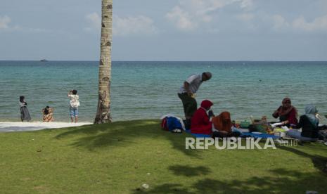 Sejumlah wisatawan bercengkerama di Pantai Teluk Lagoi, Bintan, Kepulauan Riau, Ahad (1/11/2020). Pengelola Lagoi telah menyiapkan sarana dan prasarana protokol kesehatan yang sesuai standar pemerintah maupun Organisasi Kesehatan Dunia (WHO) untuk menyambut turis asing.