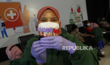 Petugas menunjukkan botol berisi darah warga yang mengikuti screening donor plasma konvalesen di terminal penumpang Gapura Surya Nusantara, Pelabuhan Tanjung Perak, Surabaya, Jawa Timur, Kamis (21/1). Kegiatan yang digelar oleh PT Pelindo III (Persero) tersebut diikuti 250 orang penyintas Covid-19 guna membantu pasien-pasien Covid-19 yang masih dirawat. 