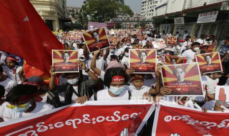  Demonstran memegang potret pemimpin sipil yang ditahan Aung San Suu Kyi selama protes menentang kudeta militer, di Yangon, Myanmar, 22 Februari 2021.