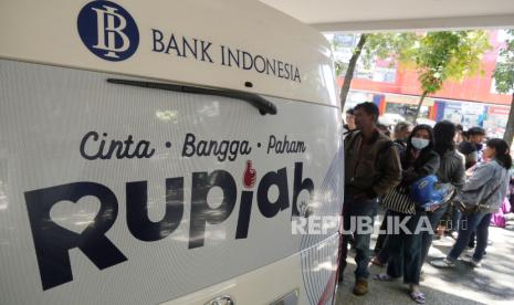 Warga antre menukar uang rupiah.