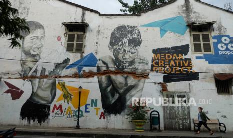 Warga melintas di depan mural di kawasan Kota Tua Kelurahan Kesawan, Medan, Sumatera Utara (ilustasi) 