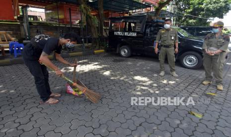 Warga pelanggar protokol kesehatan menjalani sanksi sosial. ilustrasi