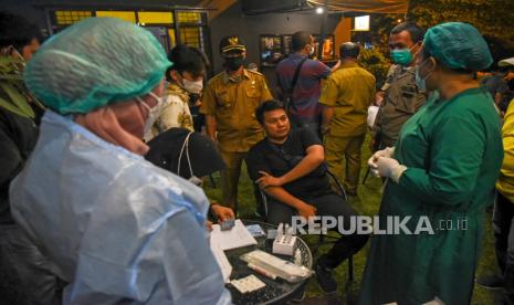 Tim Satuan Tugas COVID-19 Kota Medan yang terdiri dari aparat TNI/Polri dan Satpol PP mendatangi salah satu kafe saat razia protokol kesehatan dan tes swab antigen di Marelan, Medan, Sumatera Utara, Sabtu (12/3/2022) malam. Kegiatan tersebut bertujuan memperketat penerapan prokes di tempat-tempat umum guna mencegah penyebaran virus corona khususnya varian omicron. 