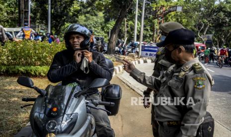 Sejumlah petugas gabungan saat menindak warga yang tidak menggunakan masker di perbatasan Depok-Jakara, Sabtu (5/9). Operasi masker yang dilakukan petugas gabungan Jawa Barat dengan DKI Jakarta tersebut sebagai bentuk pengawasan dan penindakan bagi pelanggar protokol kesehatan Covid-19. Republika/Putra M. Akbar