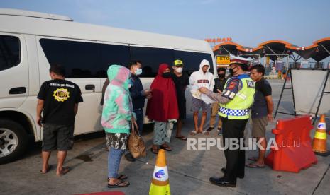 Petugas Kepolisian menurunkan penumpang yang tidak membawa kelengkapan dokumen perjalanan saat penyekatan mudik lebaran 2021 di Gerbang Tol Palimanan, Jawa Barat, Sabtu (8/5). Pada hari ketiga diberlakukannya larangan mudik lebaran, kendaraan penumpang yang tidak dilengkapi dokumen perjalanan lengkap diputarbalikkan oleh petugas di Gerbang Tol Palimanan. Foto : Edwin Putranto/Republika