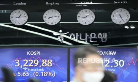 Seorang pedagang mata uang melihat monitor komputer di dekat layar yang menunjukkan Indeks Harga Saham Gabungan Korea (KOSPI), kiri, dan nilai tukar mata uang asing antara dolar AS dan won Korea Selatan di ruang transaksi valuta asing di Seoul, Korea Selatan, Kamis, 3 Juni , 2021. Saham-saham di Korea Selatan naik pada perdagangan Senin (27/9) pagi.