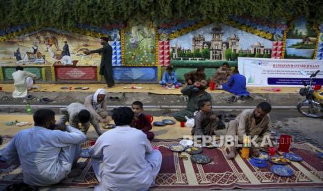 Orang-orang berbuka puasa selama bulan suci Ramadhan di sepanjang tepi jalan, di Peshawar, Pakistan, Rabu, 14 April 2021. Daftar Negara dengan Durasi Puasa Ramadhan Terpanjang dan Terpendek 2022