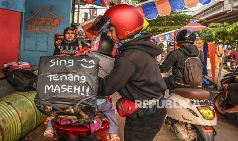 Pemudik sepeda motor bersiap melanjutkan perjalanan usai berbuka puasa di jalan raya Kalimalang, Jakarta, Kamis (27/4/2022). Pada H-4 Lebaran 2022 jalan raya Kalimalang mulai dipadati pemudik yang akan menuju ke Jawa Tengah. 