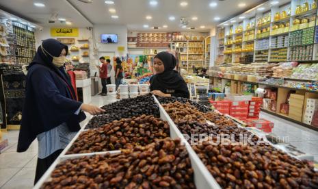 Pedagang melayani pembeli kurma di Toko Kurma Al Ghaizan di kawasan Pasar Tanah Abang, Jakarta, Rabu (28/2/2024).