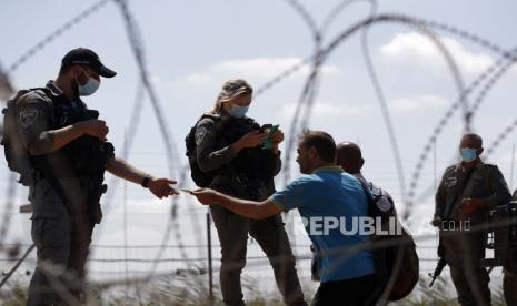  Pasukan keamanan Israel memeriksa identitas warga Palestina saat mereka mengantre dalam perjalanan kembali ke kota Jenin, Tepi Barat, melalui celah di pagar keamanan, dekat desa Israel Muqabla, 06 September 2021. Sejumlah tahanan keamanan melarikan diri dari Penjara Gilboa, demikian pernyataan Kantor Perdana Menteri Israel pada 06 September 2021.